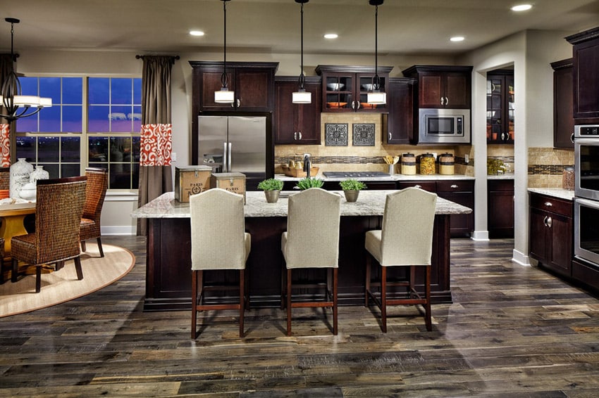 Kitchen with chandelier, white dinner chairs and curtains