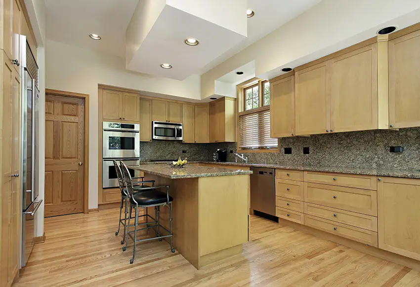 Kitchen with island for dining and light maple wood cabinets