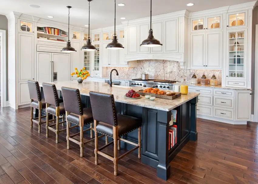 Cabinets in antique white finish, wood plank flooring and four chairs with island