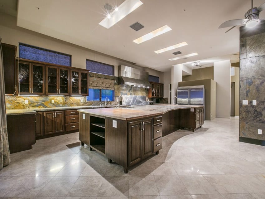 L shaped kitchen with slate backsplash granite counters and upscale finishes