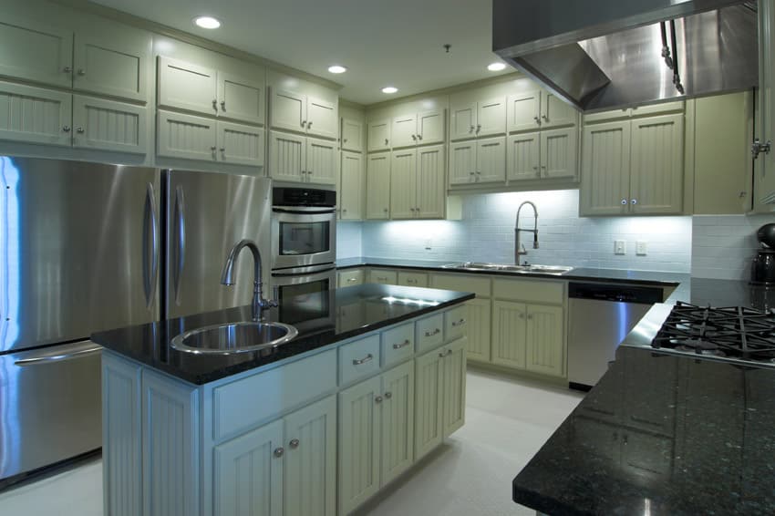 Counter with faucet, oblong sink and recessed lighting