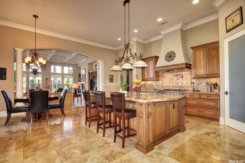 Large island with eat-in dining, wrought iron design on walls and stone backsplash