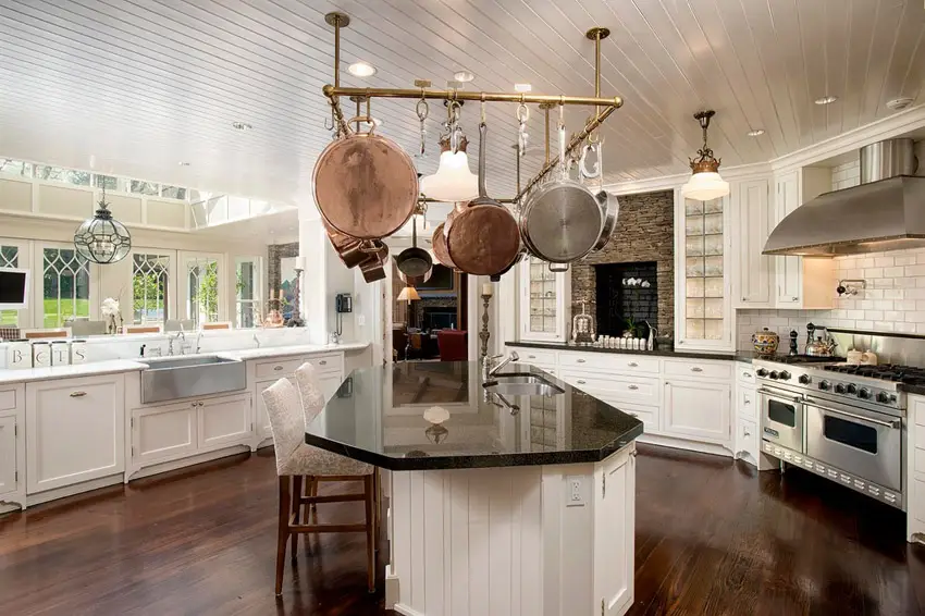 Kitchen with unique shaped island bar, skylights and glass subway tile backsplash