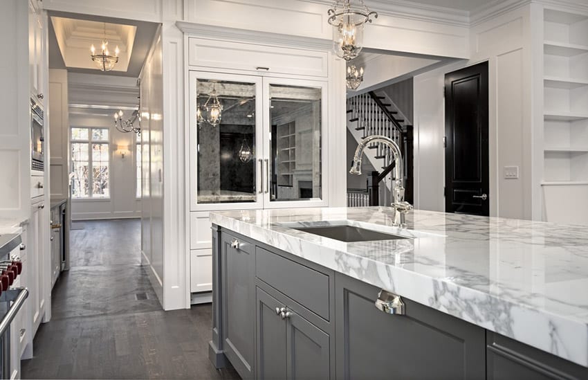 Small kitchen with white and grey cabinets and marble counter