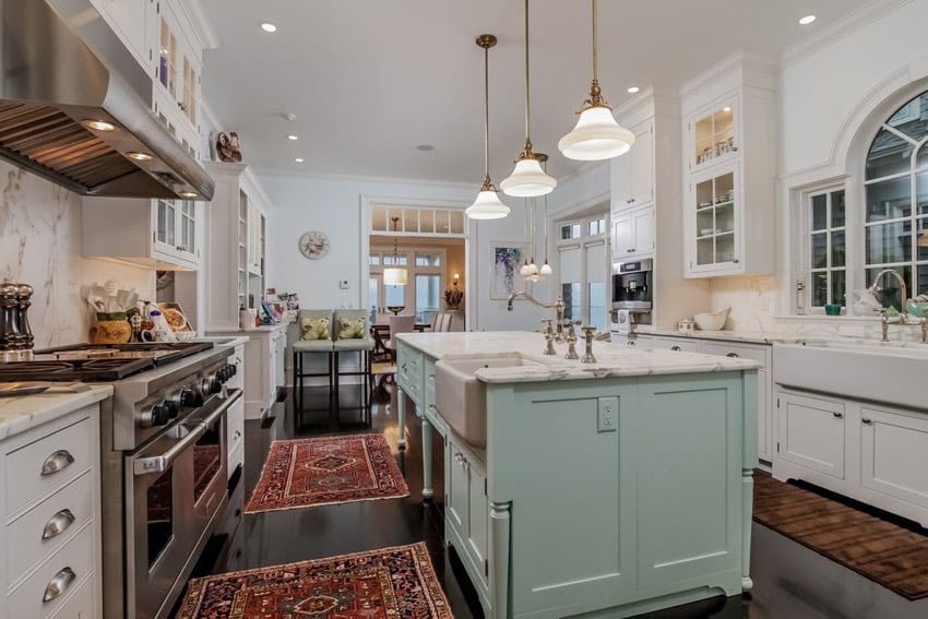 Traditional kitchen with white marble counters, farmhouse sink, and mint green island