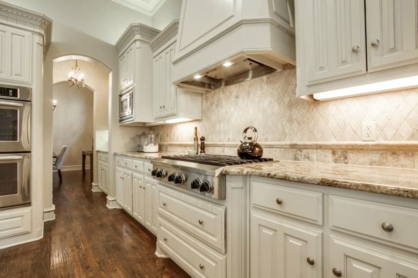 White kitchen with barricato granite counters decorative oven hood