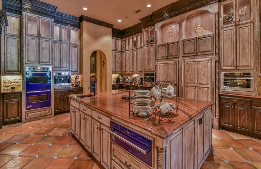 Wood traditional kitchen with spanish tile floor and red granite counters