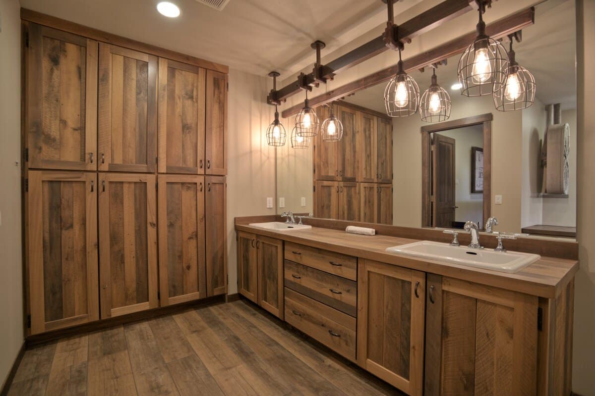Five wire cage pendant lights on a beam over a rustic wood double vanity