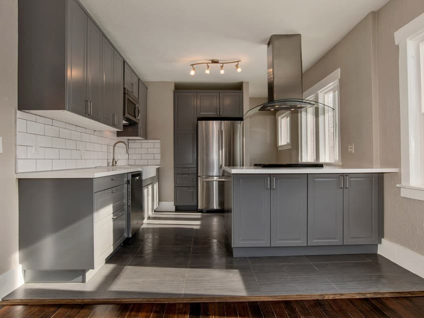 Compact closed kitchen with grey cabinets and white countertops