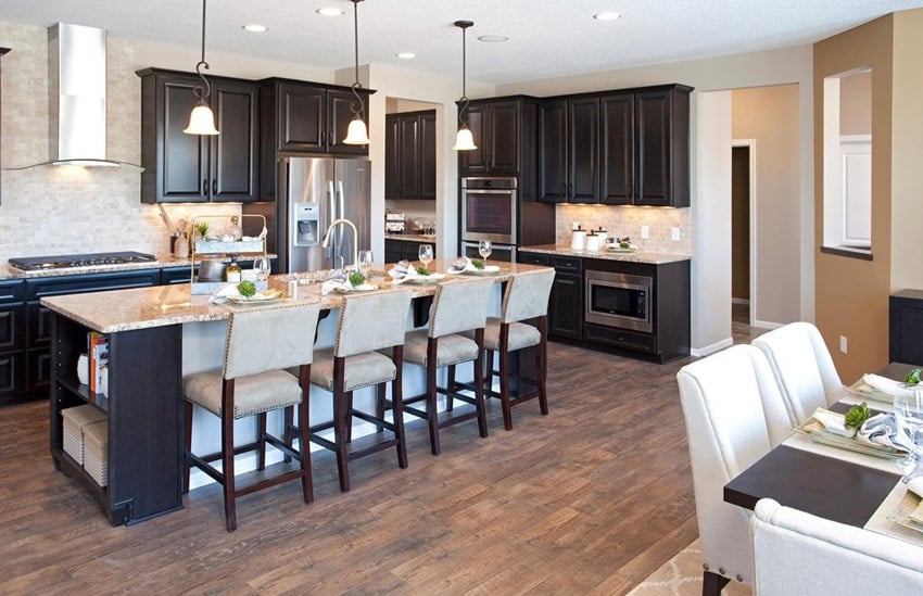 Compact traditional kitchen with island dark cabinets pendant lights