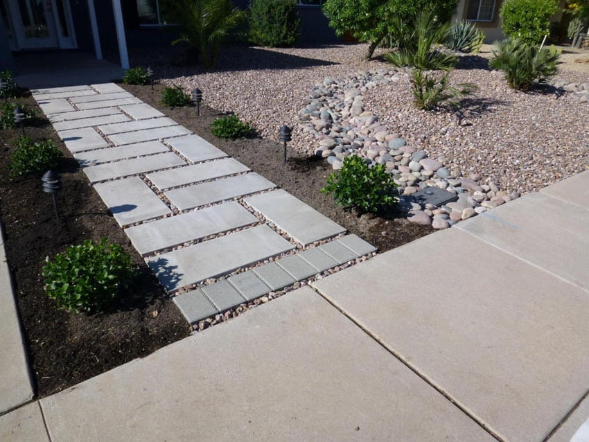 Concrete paver walkway with cobble stone next to custom stream bed