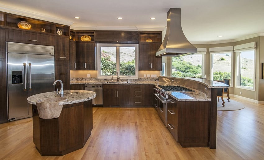 Open layout kitchen with hardwood flooring and laminated cabinets
