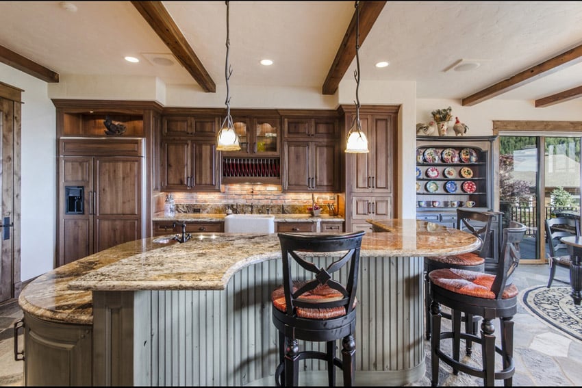 Kitchen with curved island, oak cabinets, area rug and wood beams