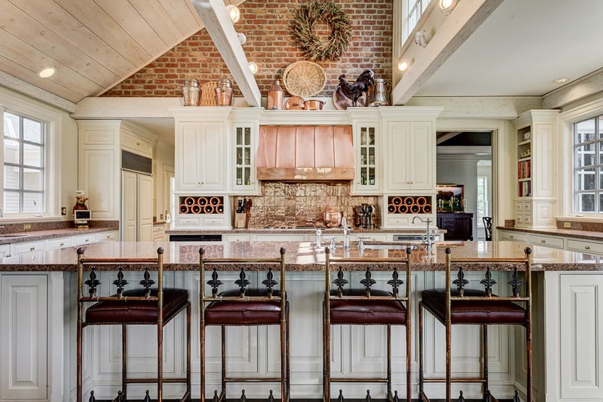 Country kitchen with copper decor above cabinets and copper oven hood