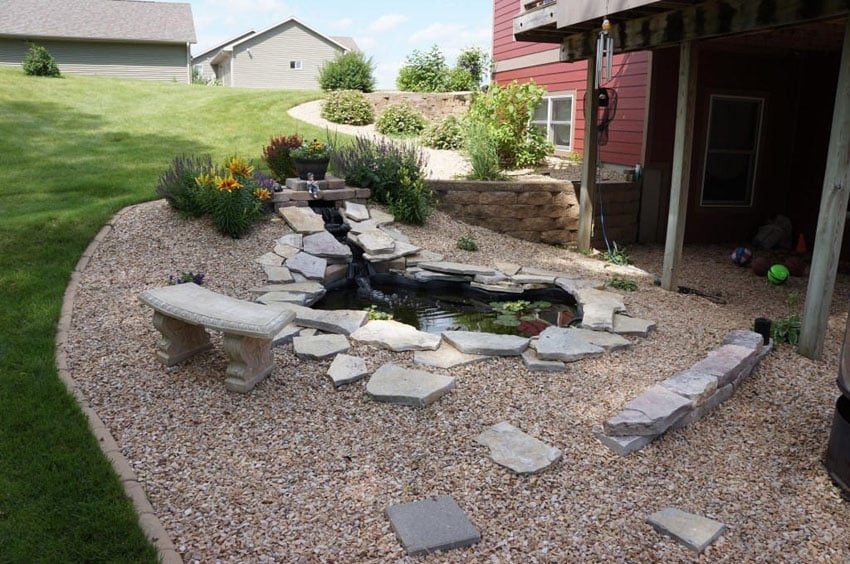 Flagstone steps and decorative rock around water feature pond