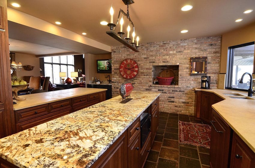 Galley style kitchen with light granite counter and brick accent wall
