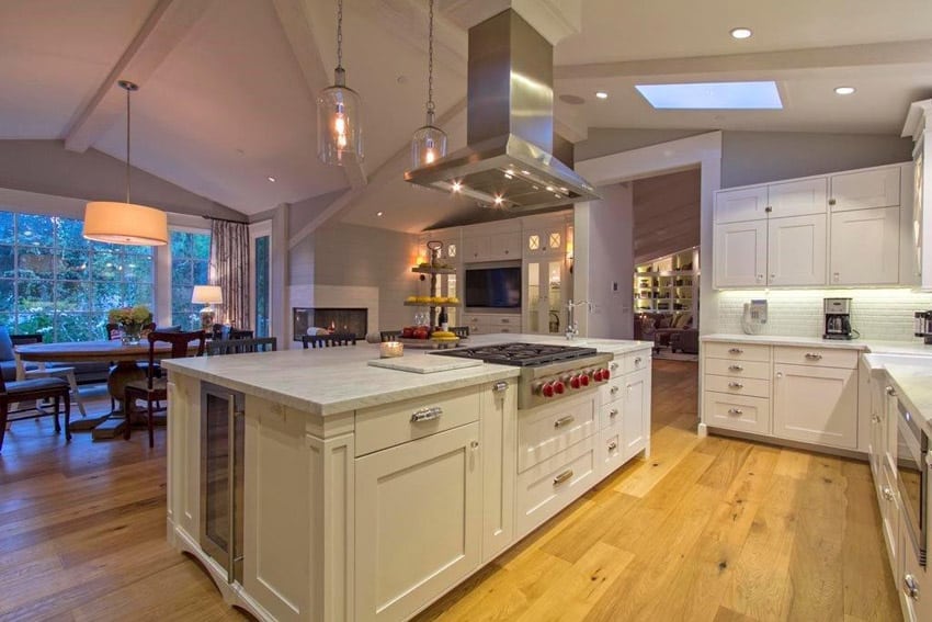Kitchen with white flat panel cabinetry marble countertops