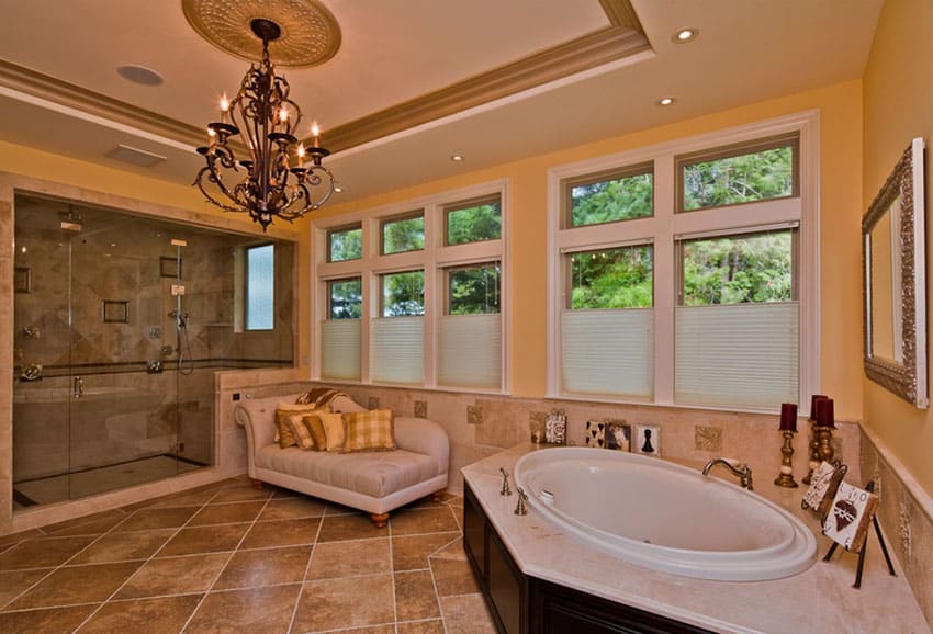 Muted luxury bathroom with chandelier, soaking bathtub, and daybed
