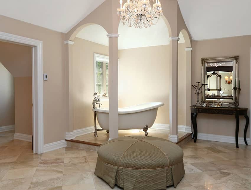 Raised clawfoot bathtub in bathroom with chandelier