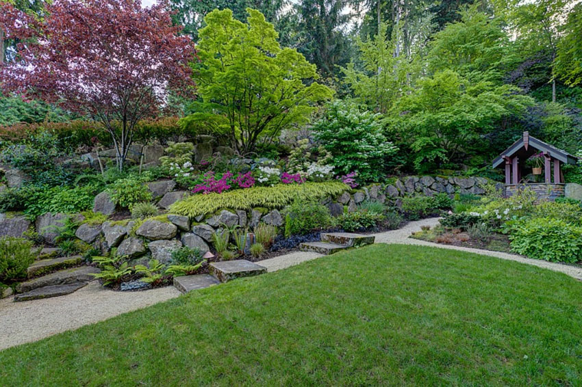 Rock garden path with granite slab steps through landscaped yard