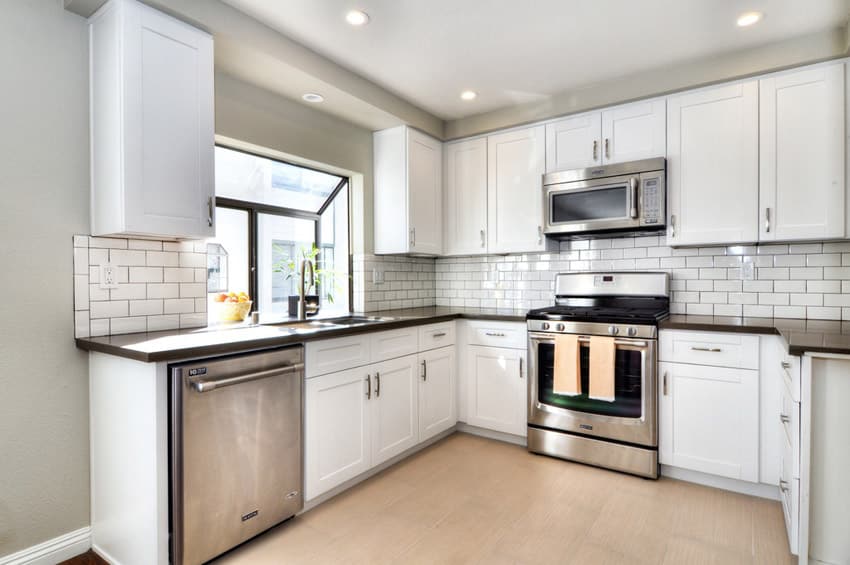 Small kitchen with dark laminate counter and white tile backsplash