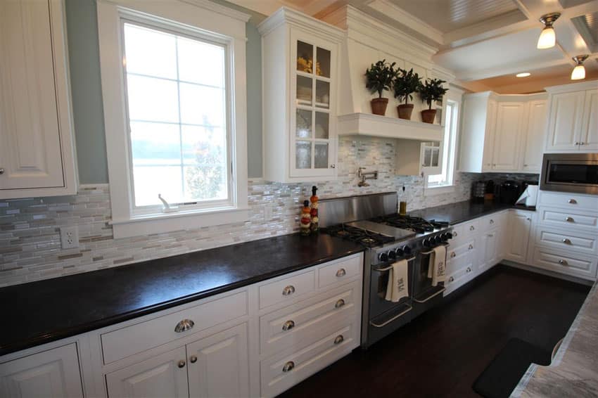 Traditional galley kitchen with white cabinets and ceramic tile backsplash