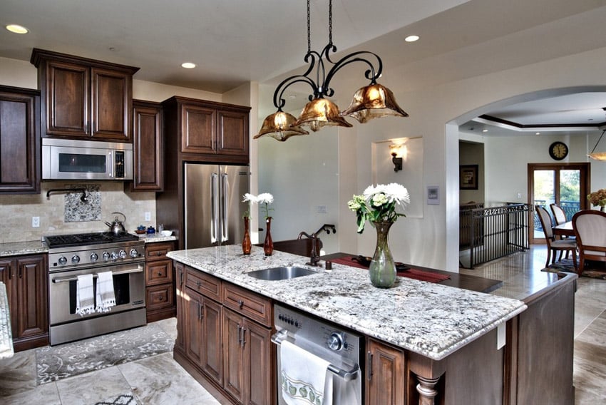 Open concept kitchen with view of the dining area via arched doorway and built in oven