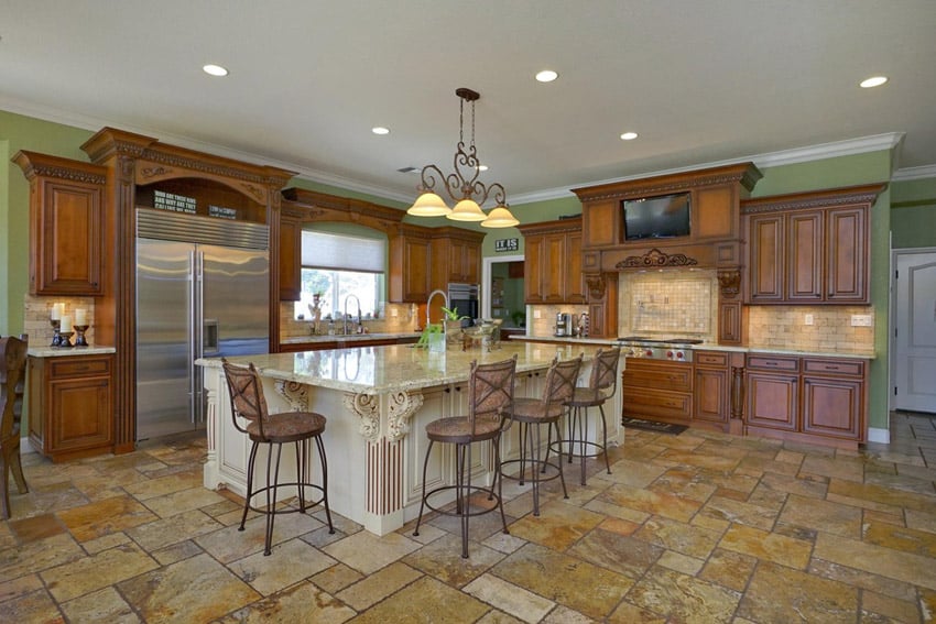 Traditional kitchen with rustic cabinetry, large island and travertine floor tiles