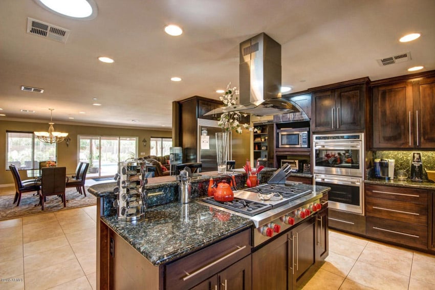 Kitchen with emerald granite counters, steel range hood and canless lighting fixtures
