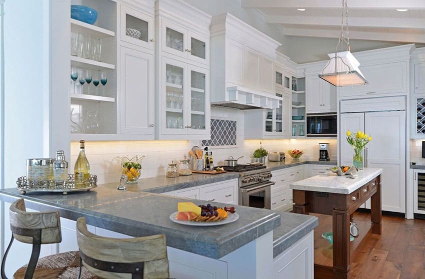 U shaped kitchen with small island with carrara marble countertop