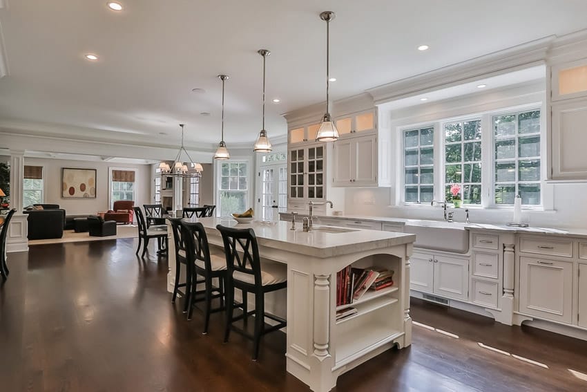 White kitchen and dining island open to living room