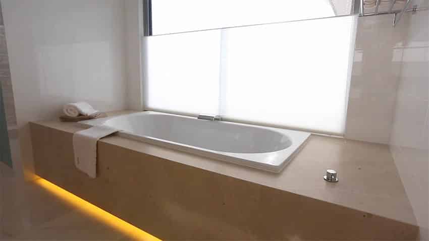 Bathtub in modern bathroom with under enclosure lighting