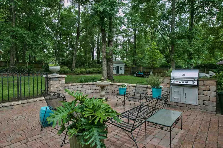 Brick paver patio with barbecue area and stone wall