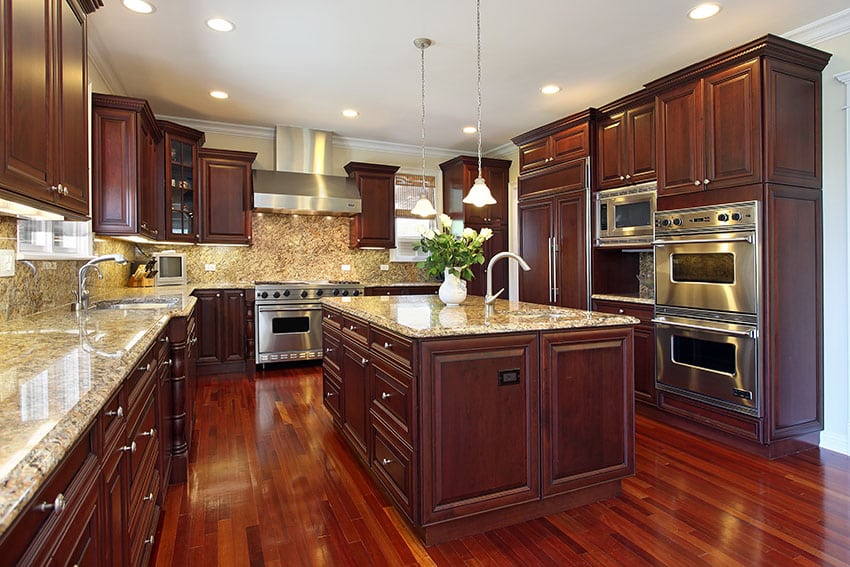 Kitchen with cabinetry made of cherrywood and granite backsplash