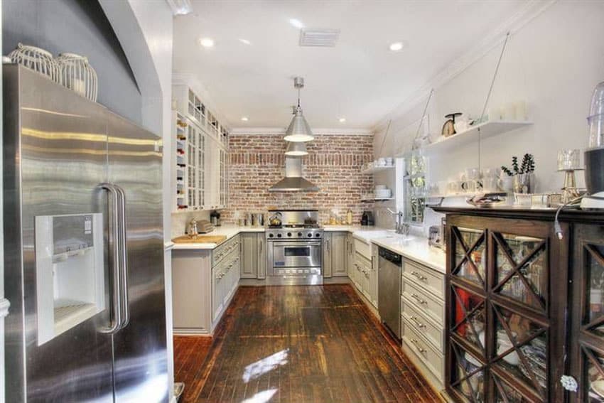 Country kitchen with brick wall and white cabinets