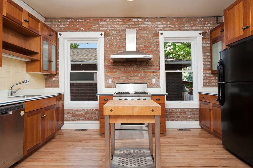 Craftsman kitchen with brick wall with windows