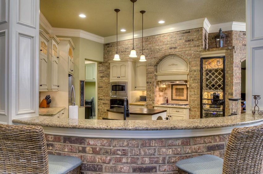Cream traditional kitchen with brick breakfast bar and brick accent wall