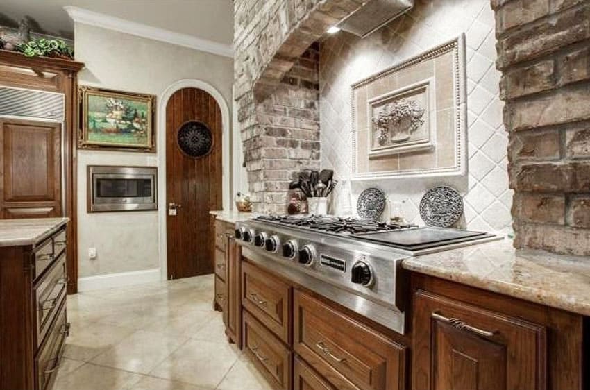 Kitchen with marble tile backsplash and brick veneer