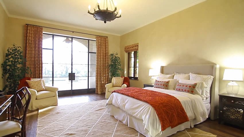 Large decorated bedroom with queen size bed and large window view