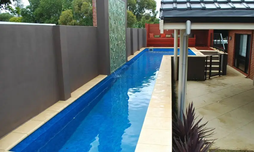 Long swimming lap pool with accent wall waterfall