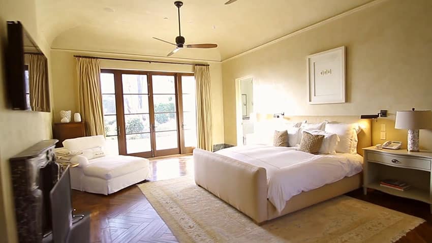 Master bedroom in luxury home with fireplace wood floors