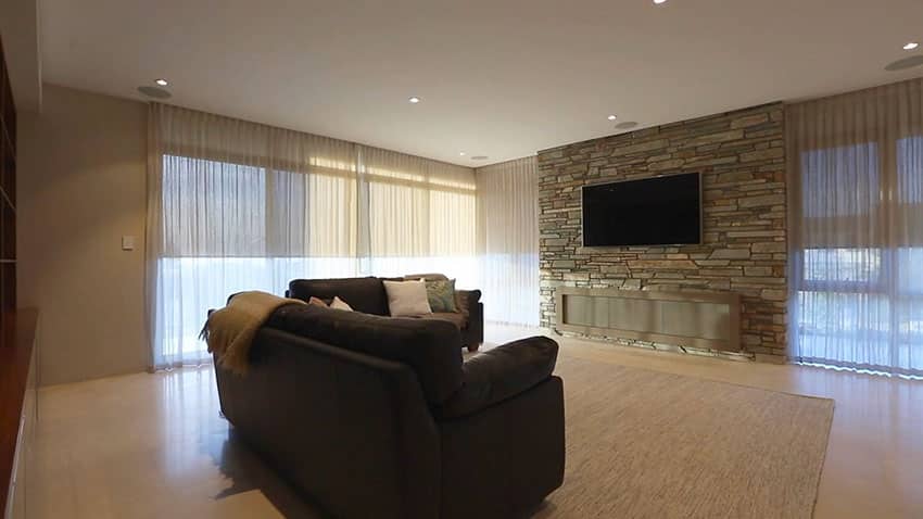 Movie room in modern home with stacked stone wall
