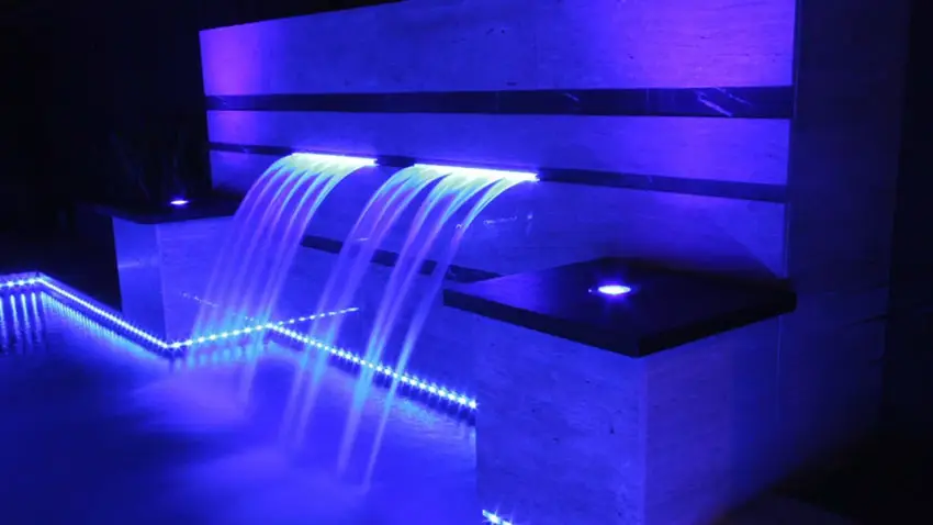 Neon water feature in swimming pool at night