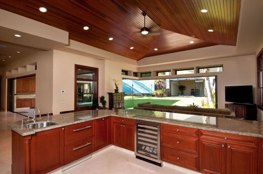 Kitchen with gabled ceiling with cherry hardwood planks and L-shaped counter
