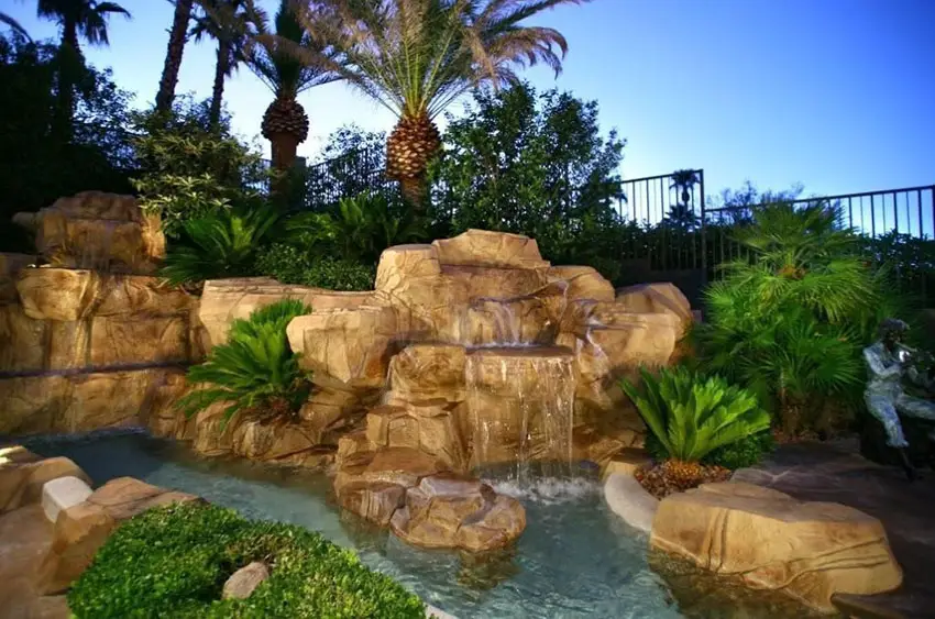 Rock water feature waterfall into pool