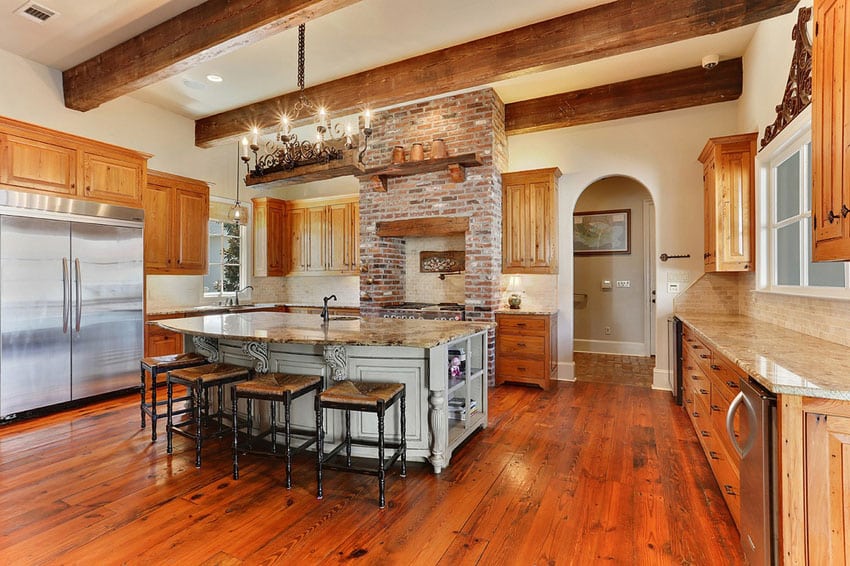 Rustic kitchen with large dining island and brick around stove