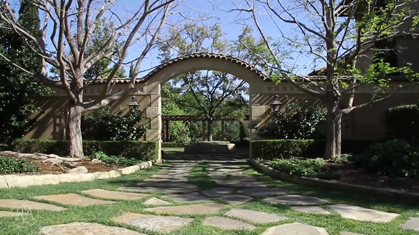 Stone pathway to backyard patio area at property