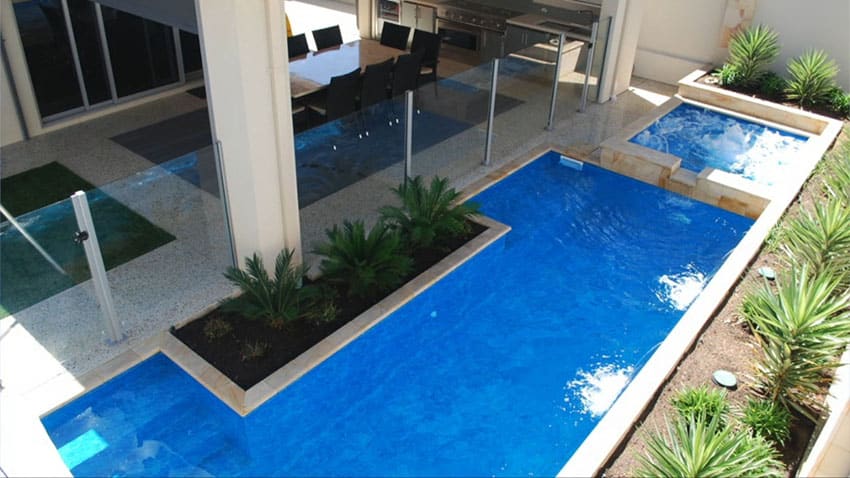 Swimming pool with narrow waterfall and spa