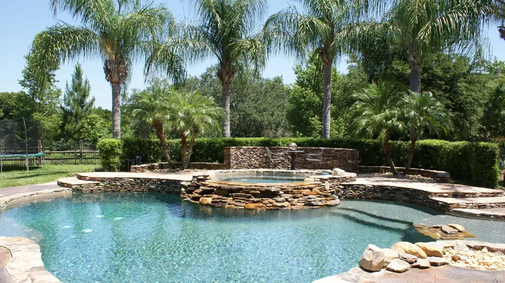 Swimming pool with stacked stone water feature