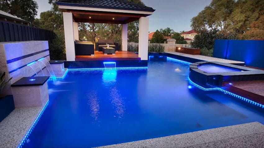 Swimming pool with water features and mood lighting at night
